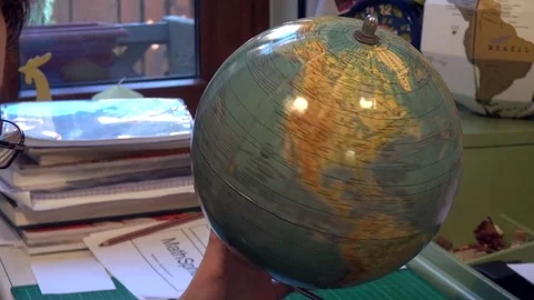 Young boy searching for countries by spinning a small globe Stock Footage 71961809