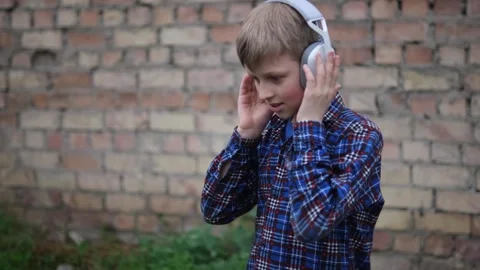 Young boy is seen in three different frames, wearing headphones and dancing Stock Footage 279091981
