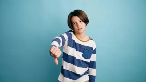 Young boy showing thumbs down expressing disapproval gesture Stock Photos