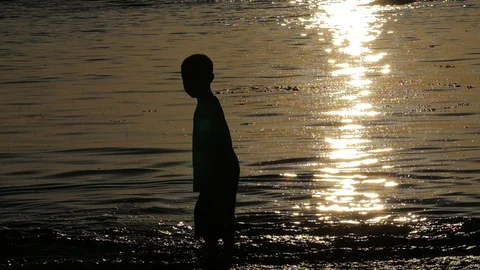 Young boy silhouette in the ocean.  Stock Footage 97098544