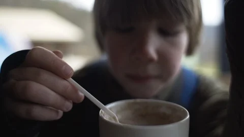 Young boy sips cocoa from spoon on cold day outside Stock Footage 102215491