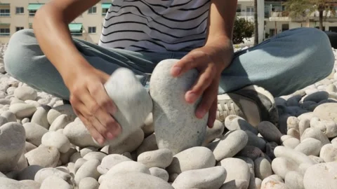 Young Boy Sit on Pebble Beach, Stacking Smooth White Stones with Care. Enga.. Stock Footage 286977252