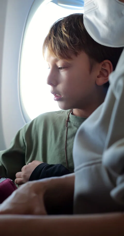 Young boy sit by window at airplane, portrait shot, slow motion Stock Footage 303993384