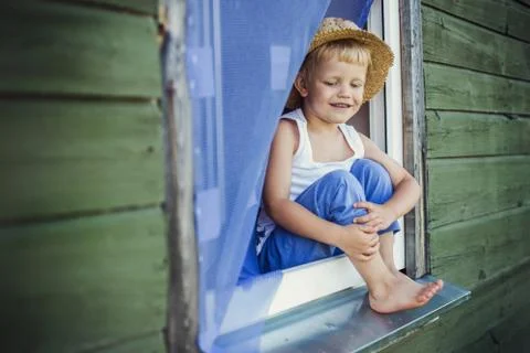 Young boy sit on the window sill Stock Photos