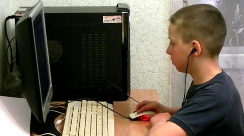 Young boy sits at computer and yawns Stock Footage 62477318