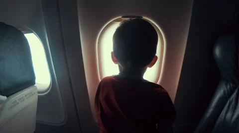 Young boy sitting in airplane looking out window Stock Footage 54342390