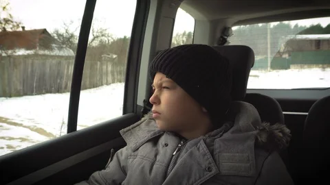 Young Boy Sitting on the back seat in a car waiting for departure, winter  Video stock 98693879
