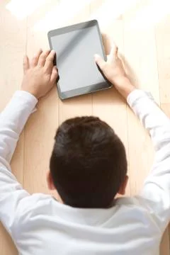 Young boy sitting with mobile table computer Fotos de archivo