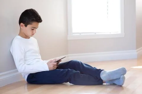Young boy sitting with mobile table computer Fotos de archivo