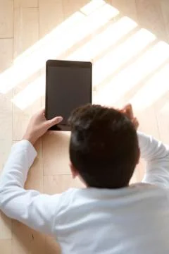 Young boy sitting with mobile table computer Fotos de archivo