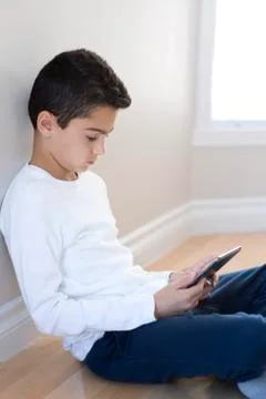 Young boy sitting with mobile tablet computer. Fotos de archivo