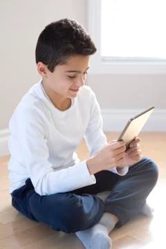 Young boy sitting with mobile tablet computer. Fotos de archivo