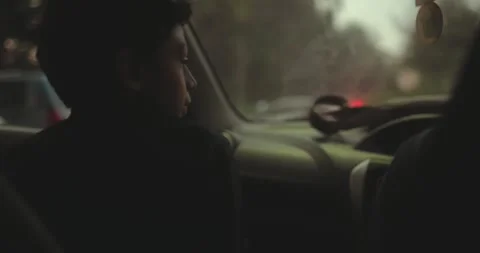 Young boy sitting quietly inside a car during a family road trip. Intimate Stock Footage 336000511
