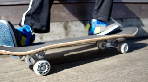 Young boy sitting, rolling his skateboard Stock Footage 36423684