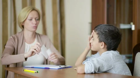 Young boy sitting in silence during session with young psychologist. Stock Footage