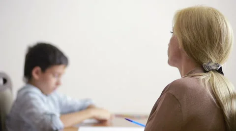 Young boy sitting in silence during session with young psychologist. Stock Footage