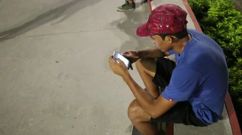 Young boy sitting on step playing on phone Video stock 66768036