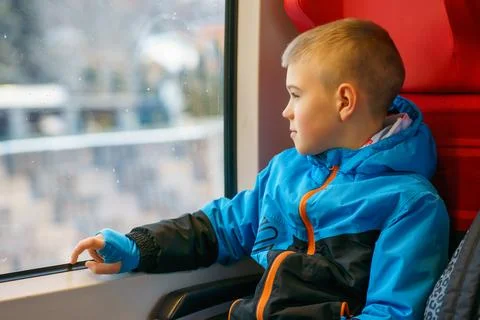 Young Boy Sitting by Train Window Looking Outside During Winter Journey Stock Photos