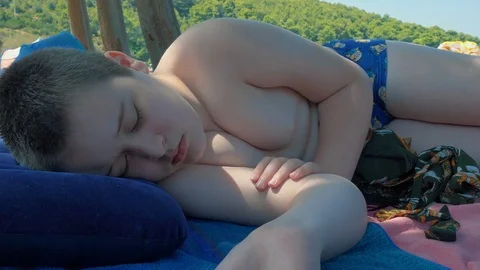 Young boy sleeping on the beach on summer vacation 스톡 동영상 84766158