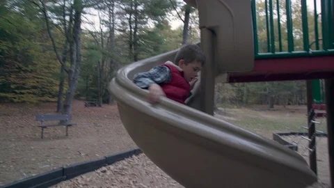 Young boy slides down spiral slide Stock Footage 81537846