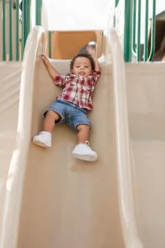 Young Boy Sliding Down Slide at Playground Stock Photos