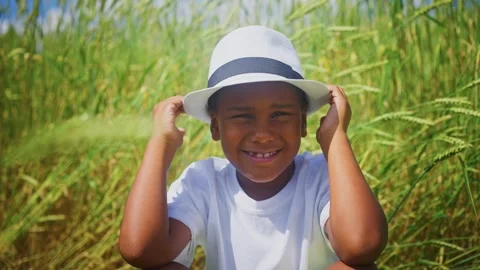 Young boy smiles joyfully while gathering rice near a golden field Stock Footage 291650843