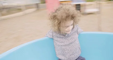 Young boy smiling and spinning around in a playground teacup ride Stock-Footage 95289909