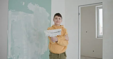 Young Boy Smiling During Home Renovation, Painting Walls Stock Footage 273498181