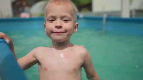 Young Boy Smiling, Happy Child By Poolside, Joyful Kid Enjoying Sunny Water 動画素材 329487394