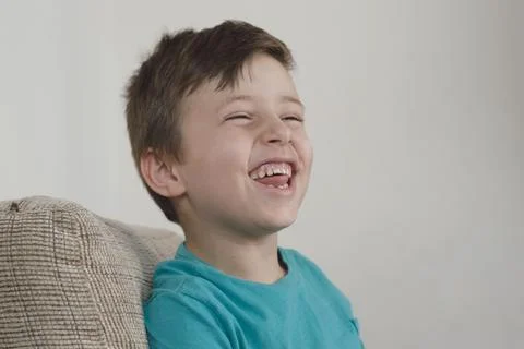 Young boy smiling using a blue t-shirt and looking to the side Foto stock