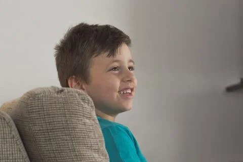 Young boy smiling using a blue t-shirt and looking to the side 스톡 사진