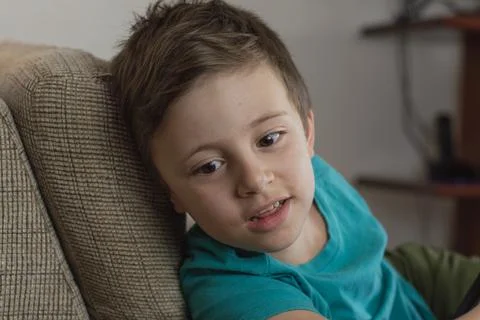 Young boy smiling using a blue t-shirt and looking to the side 스톡 사진