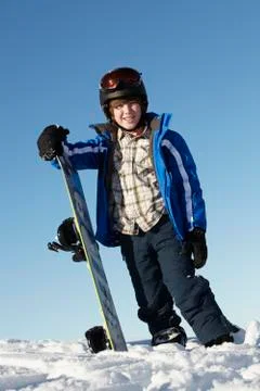 Young Boy With Snowboard On Ski Holiday In Mountains Stock Photos