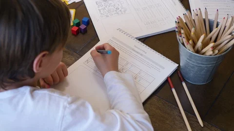 A Young Boy Solving Handwriting Activity On Book Video stock 129498943