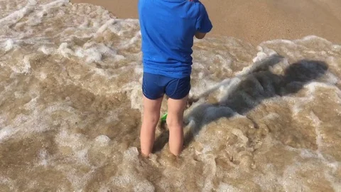 Young boy with spade playing on the beach. Stock Footage 80354122