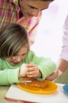 Young boy squeezing lemon over fish sticks Stock Photos