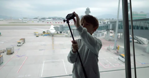 Young boy stand with action camera at airport terminal Stock-Footage 324861929