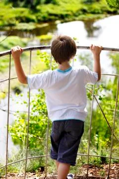 Young boy standing on the edge before observing nature landscape Stock Photos