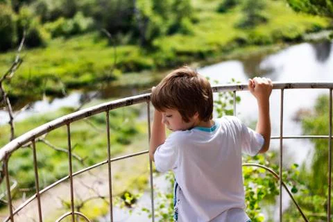 Young boy standing on the edge before observing nature landscape Stock Photos