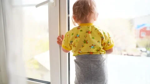 A young boy standing in front of a window Stock Footage 130565980