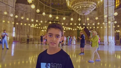 A young boy standing in a large room with lots of people Stock-Footage 291606483