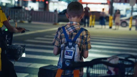 A Young Boy Stands on the Intersection Facing the Traffic Waiting a Green Stock Footage 111316211