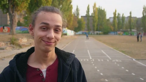 Young boy stands on the running track and smiles on camera Видео 96922848