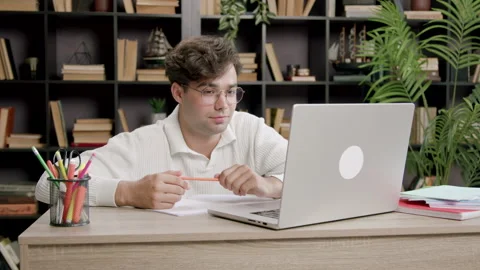Young boy stares at a computer screen and smiles discreetly. Handsome boy Stock Footage 316089759