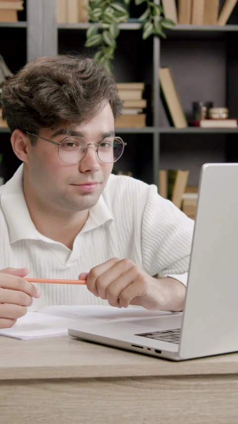 Young boy stares at a computer screen and smiles discreetly. Handsome boy Stock Footage 316603860