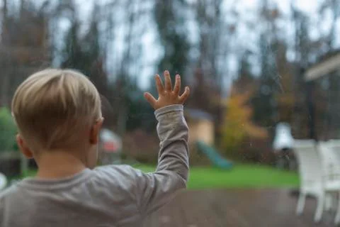 Young boy staring out of a view window Stock Photos