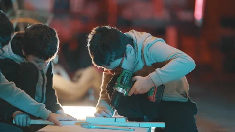 Young boy student learning carpentry using drill Stock Footage 329544616