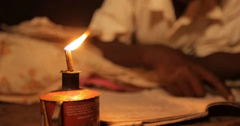 A young boy studying for his homework with Oil Lamp Uganda  Stock Footage 109493315