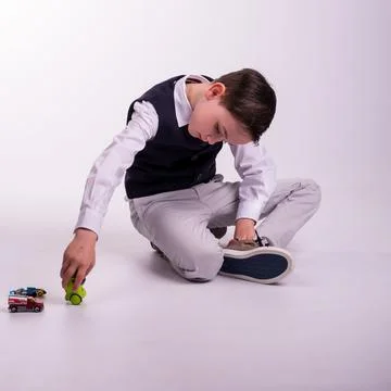 Young boy in suit sitting down playing Stock Photos