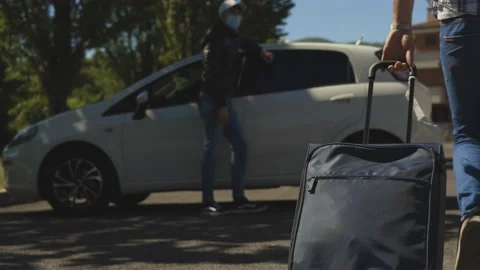 A young boy with a summer hat and suitcase meets and greets his friend, Covid Stock Footage 155248986